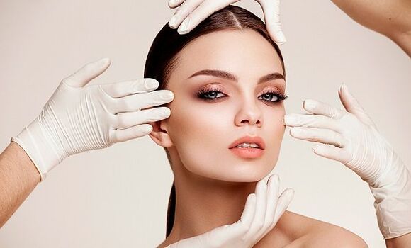 Hands in gloves at the girl's face
